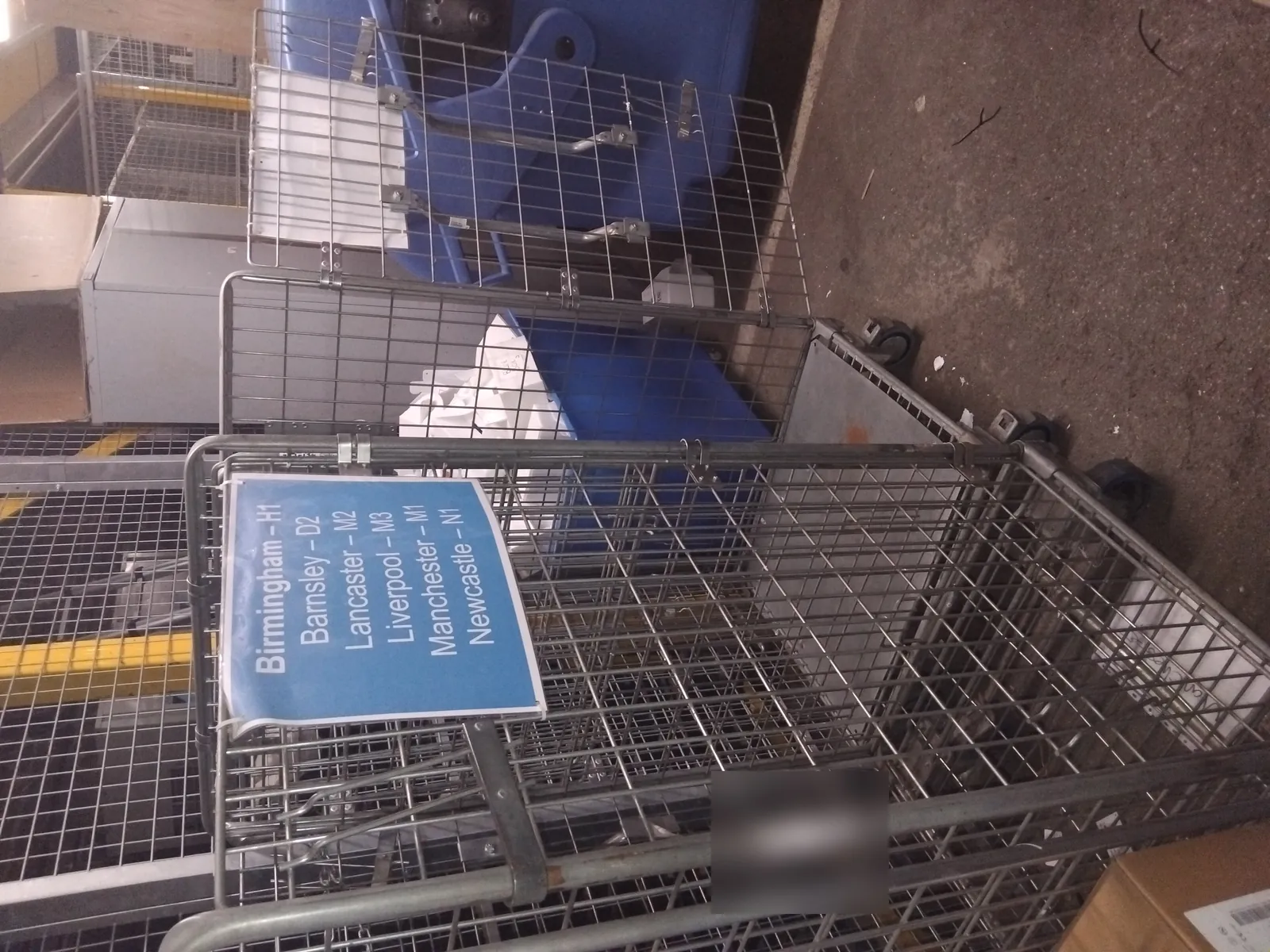 Sortation cage labelled with UK cities including Manchester, Birmingham, Liverpool and Newcastle for Red Eagle Logistics nationwide courier routes